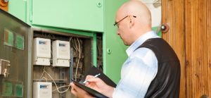 Electricista inspeccionando conexión de cableado en cuadro de fusibles