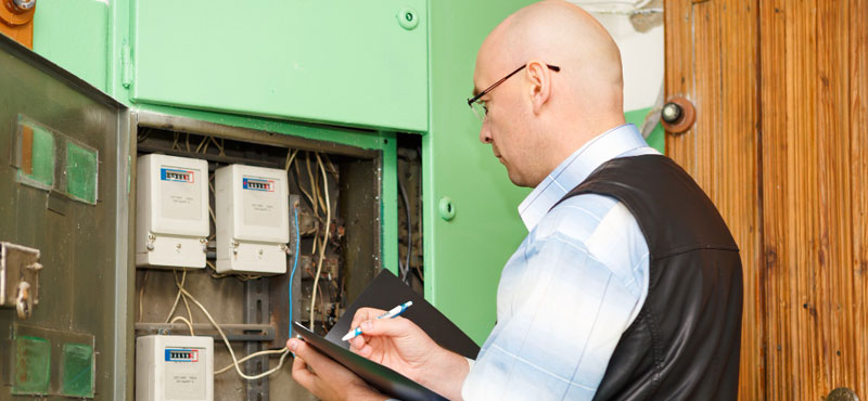 Electricista inspeccionando conexión de cableado en cuadro de fusibles