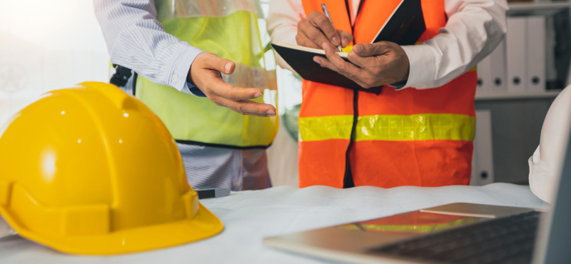 Plano cerrado de dos personas trabajando en oficina mostrando las diferencias entre ntc 2050 y RETIE normas eléctricas aplicadas con RTL Certifications