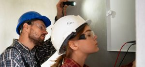 Dos personas expertas de RTL mostrando que son las instalaciones básicas eléctricas de un lugar