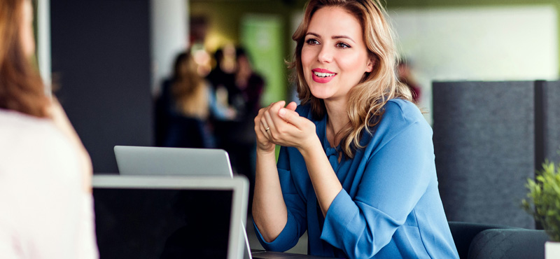 Empresaria sentada frente a experto de RTL Certifications realizando la consulta de dictamen RETIE de su proyecto