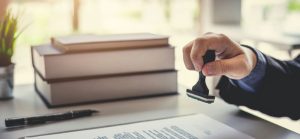 Plano cerrado de persona firmando y sellando listado de normas IEC - RTL Certifications