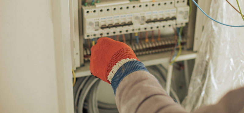 Plano cerrado de experto realizando instalación eléctrica para mostrar que tipo de norma IEC se aplican - RTL Certifications